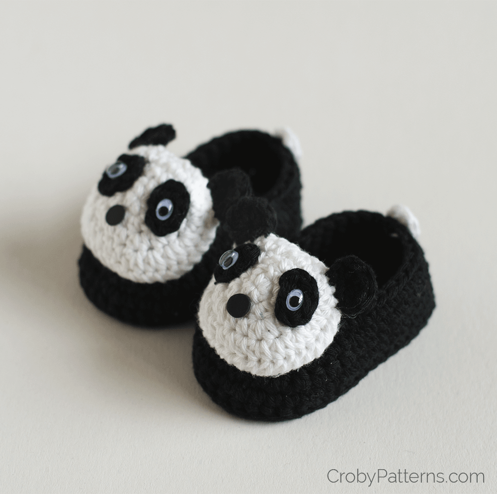 A pair of tiny crocheted panda baby booties, cozy and cute.