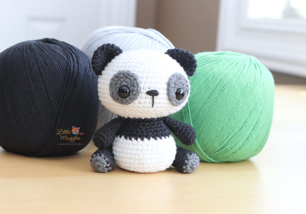 A tiny panda plushie, palm-sized, made with cotton yarn.